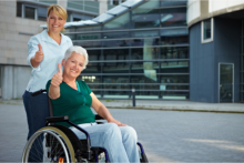 Caregiver with female elder in wheelchair